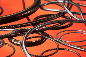 Coiled film reels are scattered on a vibrant orange surface, creating a dynamic, artistic arrangement. The image evokes a sense of nostalgia and creativity.