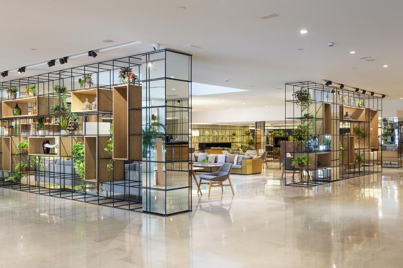 Spacious hotel lobby with modern furniture and decorative shelving.
