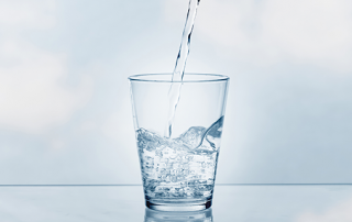 Water being poured into a clear glass.