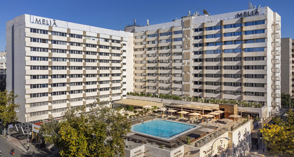 Exterior view of the Meliá Sevilla hotel with a central outdoor pool.