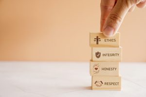 Hand holding wooden block with code of conduct concept, ethics, integrity, honesty, respect.